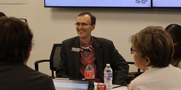 MGA Student Success Associate Director Paul Johnson smiling and laughing at a table at the USG Learning Center Summit.